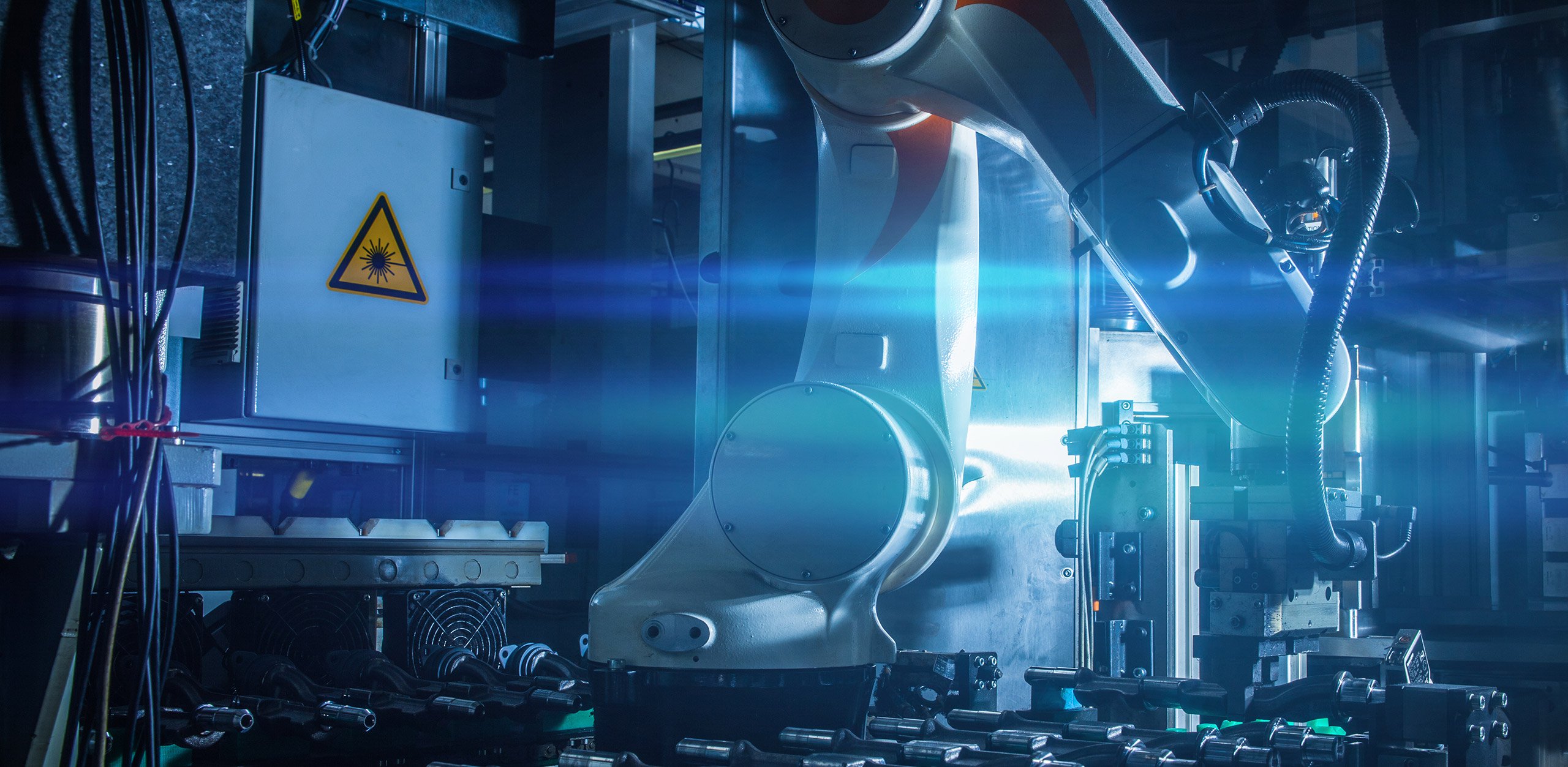 Ein weißer Roboterarm führt präzise Laserbearbeitung an einem Werkstück durch; Technologie von MFT GmbH. Ein weißer Roboterarm führt präzise Laserbearbeitung an einem Werkstück durch; Technologie von MFT GmbH.